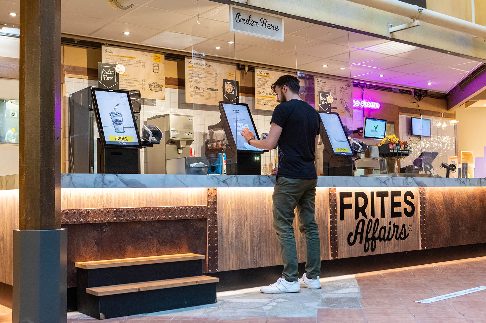 Klant bestelt bij bestelzuil in snackbar